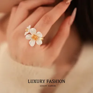 Elegant gold plated open ring featuring white flower petals and a yellow zircon gemstone
