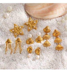 Detailed shot of starfish and shell earrings with pearls on white sand background