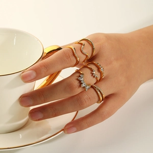 Detail of five 18k gold plated stainless steel rings with zircon stones worn by a woman