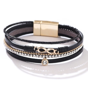 Dettaglio del bracciale multistrato in pelle con ciondolo infinito dorato e strass