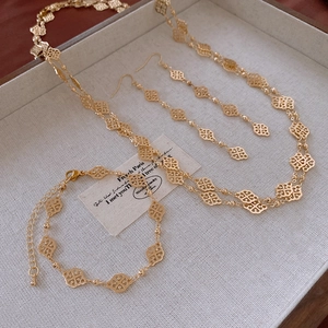 Macro view of vintage gold hollow flower necklace, bracelet and earring jewelry set