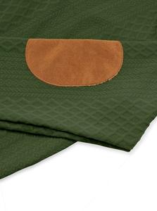 Close-up of dark green diamond-knit fabric and brown suede elbow patch with stitching