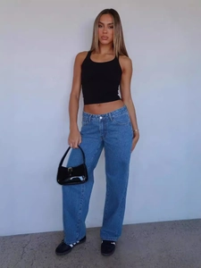 Relaxed fit blue straight leg jeans styled with a black tank top and handbag