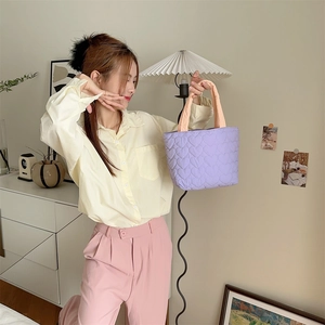 Quilted heart pattern tote bag in purple shown in a cozy lifestyle indoor setting