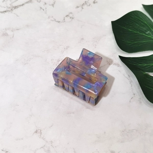 Top view of square acetate hair claw with purple and blue marble swirl pattern