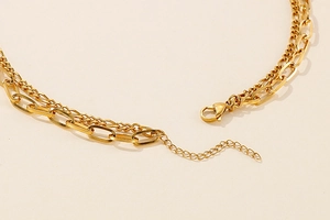 Detail of gold double-layer chain with paperclip links, lobster clasp, and extender