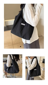 Drei Ansichten einer großen schwarzen Falten-Tasche mit Kiss Yourself Label auf Schulter