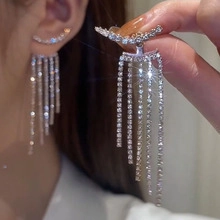 Close-up of sparkling silver tassel earrings with crystal rhinestones for women