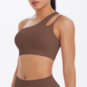 Detail of asymmetric brown one-shoulder sports bra with cutout double straps and high elastic fabric