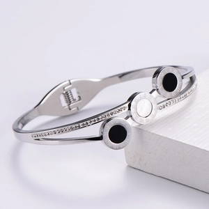 Detailed view of silver titanium steel bangle with Roman numerals and white zircon inlay