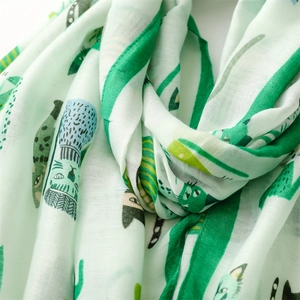 Close-up of soft light green scarf with cute cat prints showing fabric texture and detail