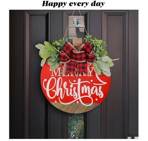 Detail of wooden Merry Christmas door wreath with red buffalo plaid bow and greenery decor
