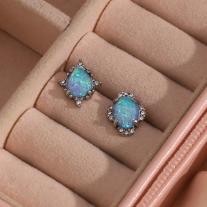 Detail of teardrop and oval earrings with blue opal and rhinestones in a pink box