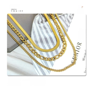 Detailed view of layered 18k gold plated titanium steel Figaro and herringbone chains