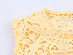 Close-up of elegant yellow lace embroidery and hollow-out texture on shoulder fabric
