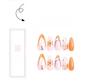 Détails de faux ongles amande orange et rose avec motifs marguerites et strass brillants