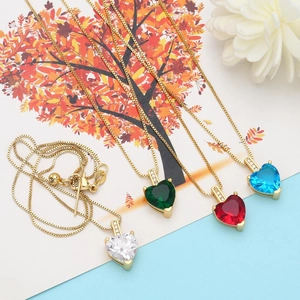Détail de quatre pendentifs coeur en zircon coloré sur des chaînes box dorées pour femmes