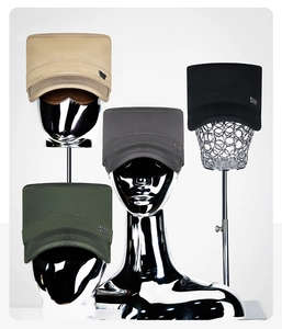 Detail view of khaki, black, grey, and olive green cotton cadet caps with metal brand tags
