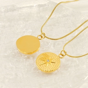 Macro detail of gold-plated stainless steel tarot necklace with starburst coin pendant