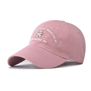 Detailed close-up of pink cotton baseball cap with cute bear embroidery and text