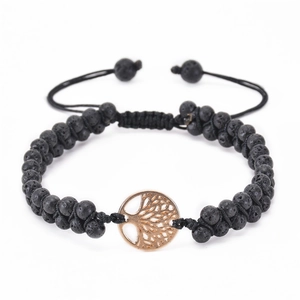 Macro detail of natural lava stone beads and tree of life charm on a braided bracelet