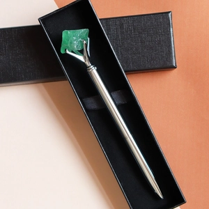 Silver metal ballpoint pen with green raw crystal stone top in a black gift box