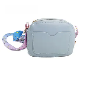 Detail of light blue unicorn crossbody bag showing the card slot and colorful printed strap