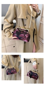 Detail of embroidered floral shell bag with golden metal frame and pearl strap