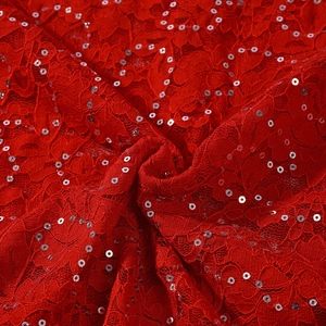 Detailed close-up of red lace fabric featuring shimmering silver sequins and elegant textures