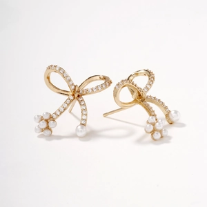 Elegant gold bow earrings with small white pearls and shimmering zircon for women