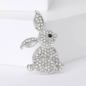 Close-up of a silver rabbit brooch with sparkling rhinestones and black stone eyes