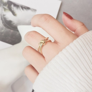 Close-up of a stylish 18K gold plated stainless steel knotted ring on a model finger