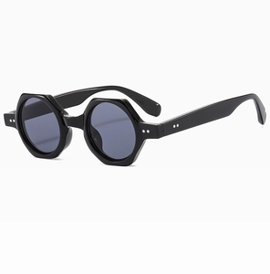 Detail of retro hexagonal sunglasses with dark grey round lenses and silver rivets