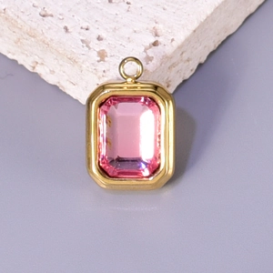 Close-up of golden rectangular pendant featuring a pink gem for DIY jewelry crafting