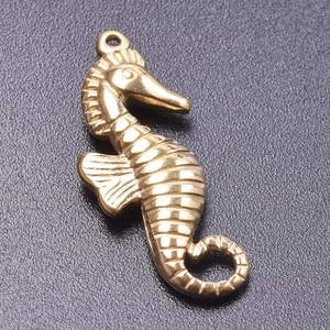 Detailed macro view of a vintage gold-plated seahorse pendant with exquisite carvings