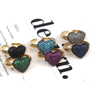 Close-up of gold heart rings set with multicolored zircon stones on a magazine