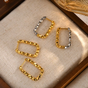 Detailed macro view of gold-plated stainless steel geometric earrings with diamond patterns