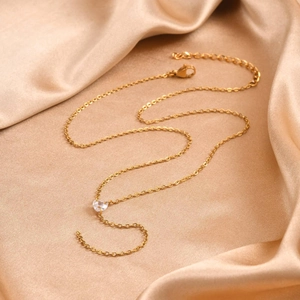 Detail of gold chain necklace with a sparkling heart-shaped cubic zirconia pendant