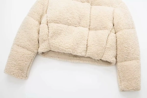 Gros plan sur la texture de la veste polaire blanc cassé avec motif à carreaux cousus