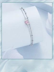 Detail view of double-layer S925 silver bracelet with pink heart zircon on white pedestal