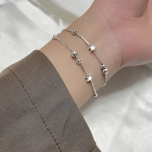 Double-layer silver beaded bracelet featuring a star pendant and polished metal spheres