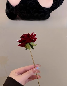 Close-up of a vintage dark red rose hair pin with golden stem and sparkling flower petals