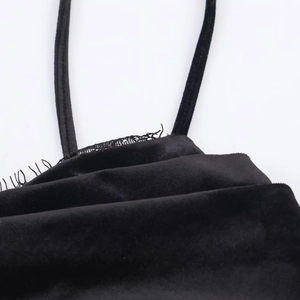 Dettaglio del tessuto in velluto nero con bordo in pizzo e spalline sottili eleganti