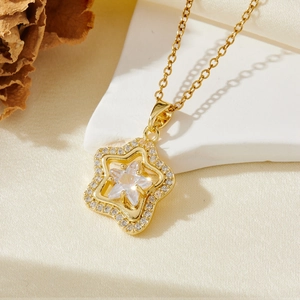 Detailed view of a gold star pendant necklace with star-cut zircon on white satin stone