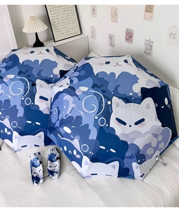 Detail of cute cat printed folding umbrellas with matching storage pouches on white bedding