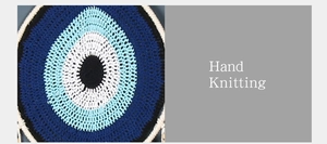Close-up of hand-knitted bohemian evil eye dreamcatcher wall hanging with blue feathers