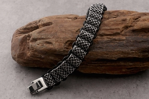 Macro detail of men's braided stainless steel bracelet with vintage celtic knot texture