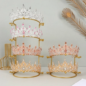 Golden metal display stands featuring elegant rhinestone bridal crowns in multiple colors