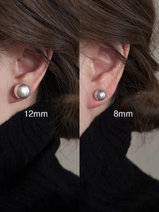 Confronto tra orecchini a sfera d'argento da 8mm e 12mm indossati per la dimensione