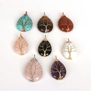 Detail of tree of life pendants in teardrop shape with handmade wire wrapped crystals